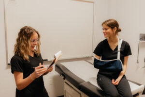 Two Medical Assistant students in a mock clinic room