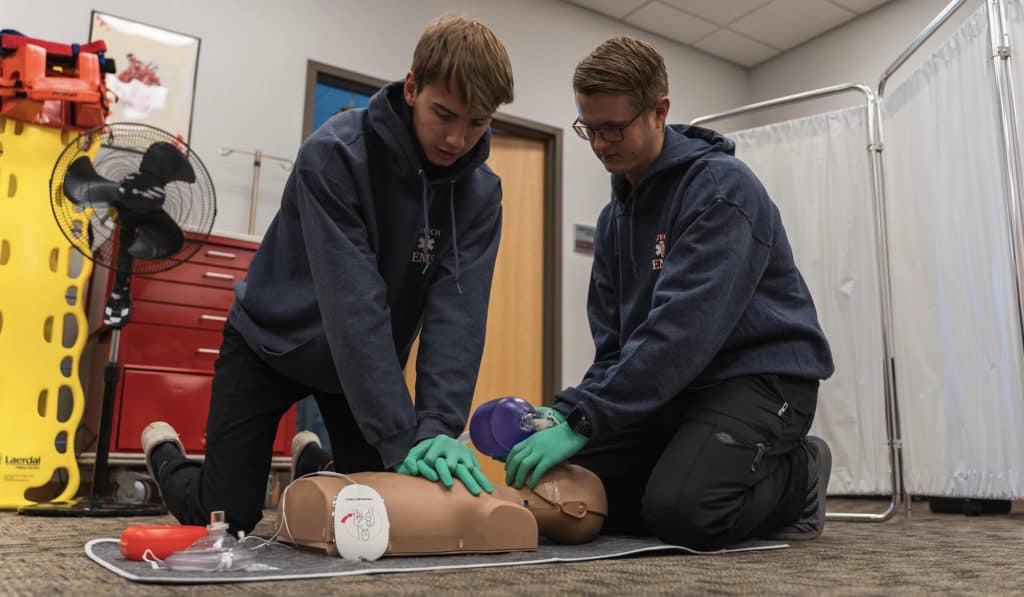 EMT students resuscitating a training manikin