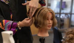 Hair Design student cutting mannequin hair