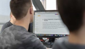 Digital Marketing students editing slides on computer screen