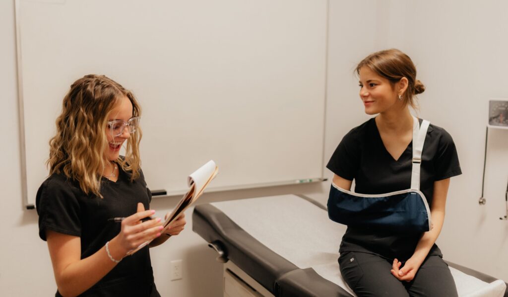 Nursing Assistant students standing in a mock clinic room