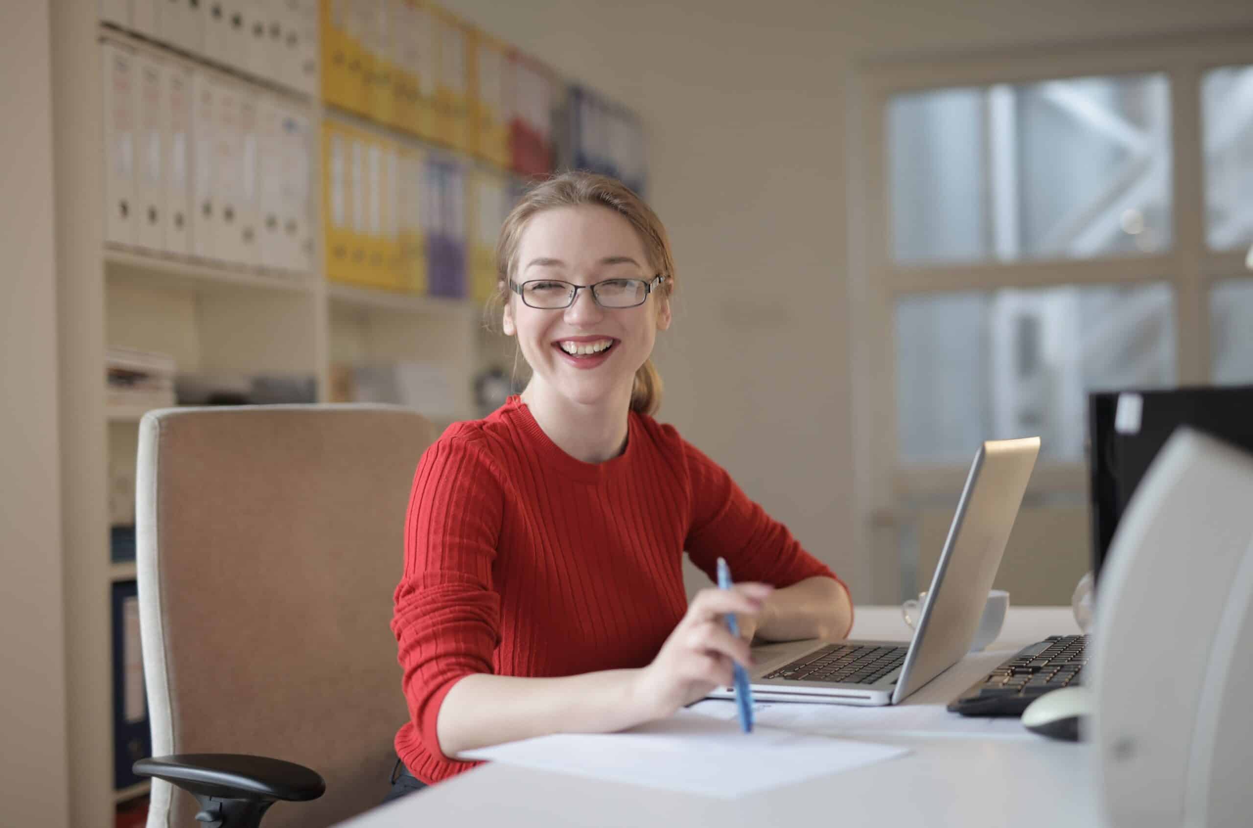 girl smiling and sitting at computer