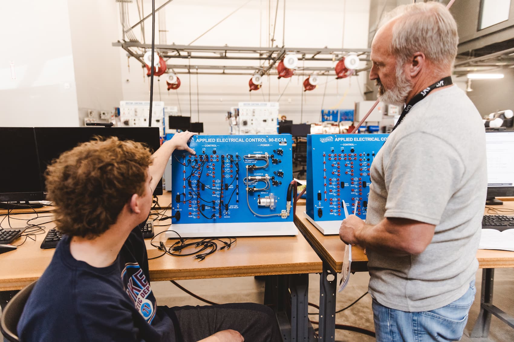 An student demonstrating using electrical controls to instructor