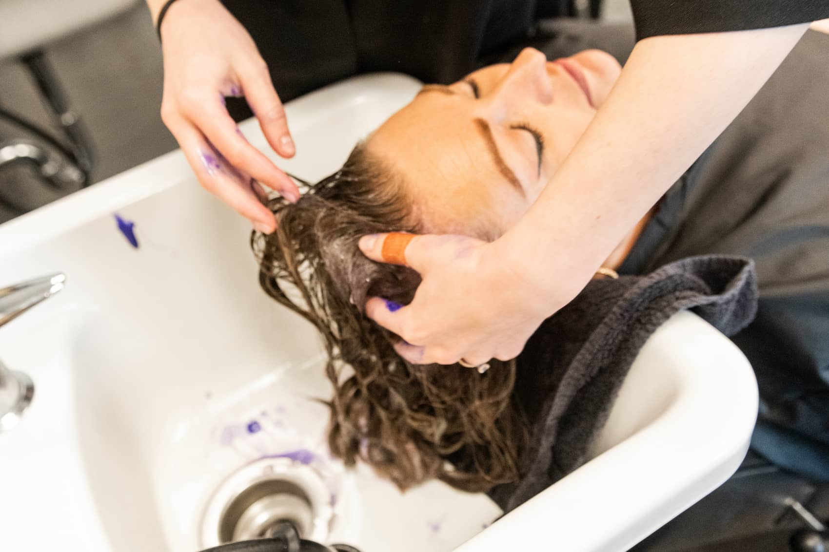 Cosmetology student washing someone's hair