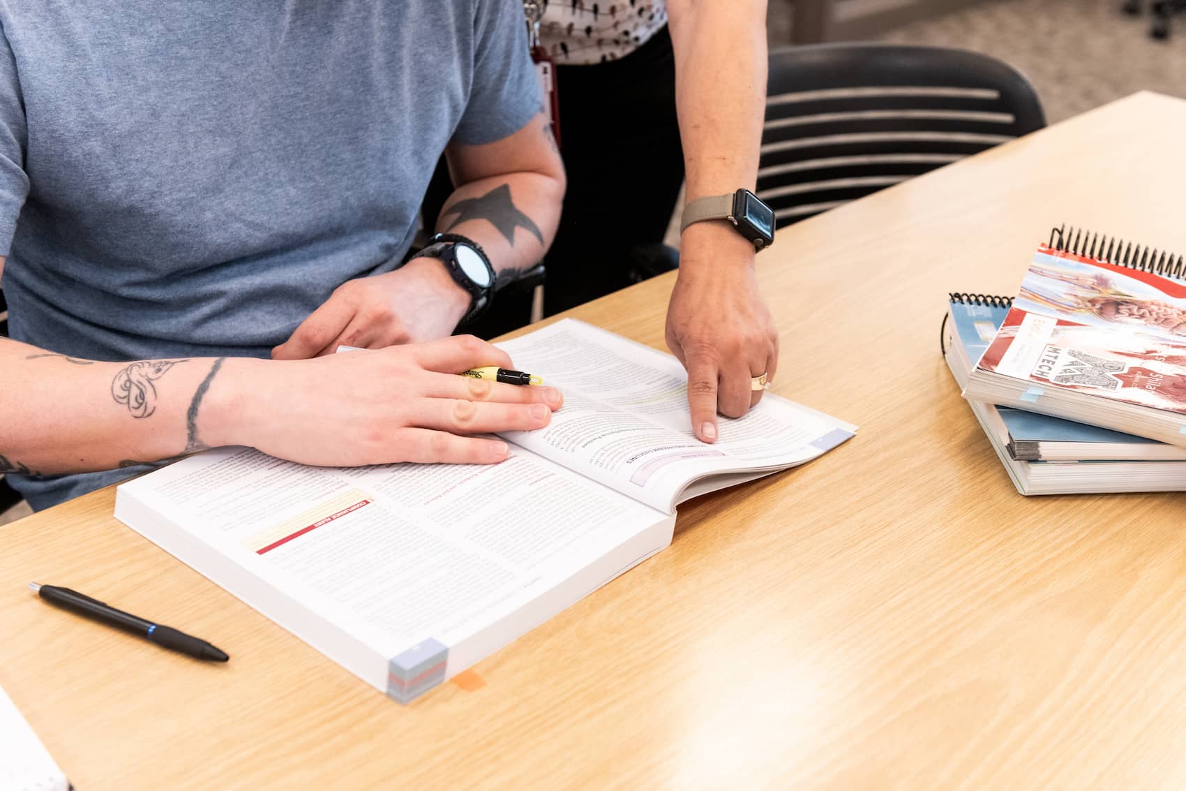 Student receiving instructor help with workbook assignment