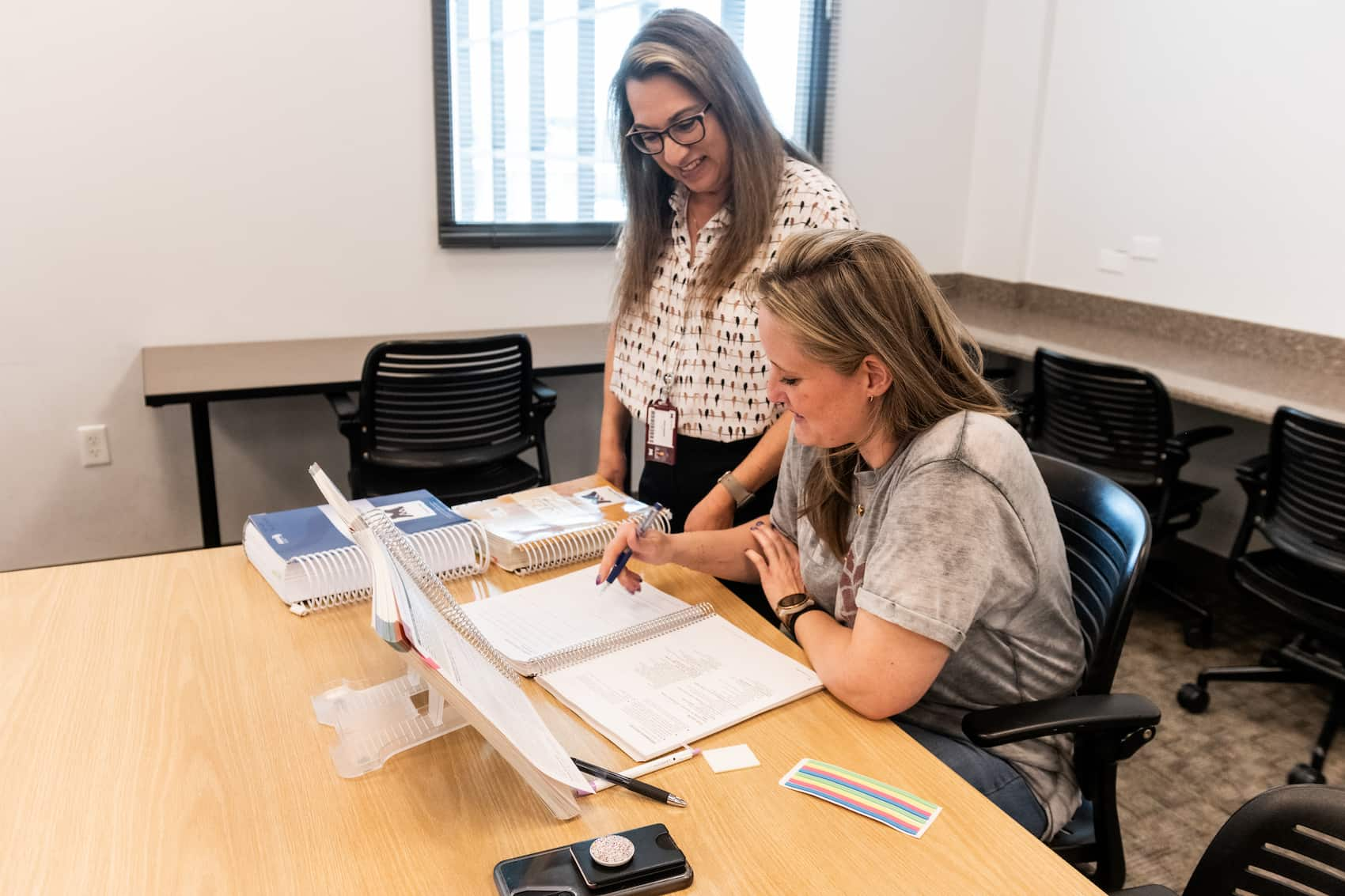 Student receiving instructor help with workbook assignment