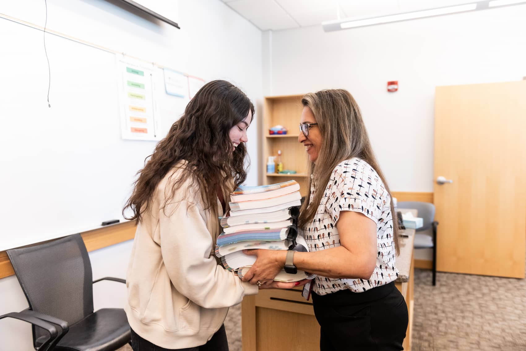 Teacher handing student 9 books