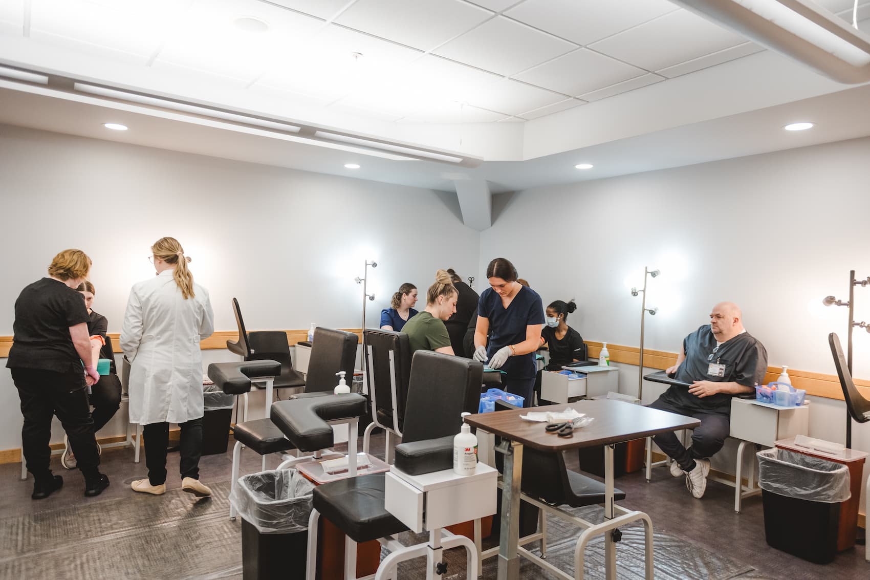 Classroom of students preparing to practice phlebotomy jabs