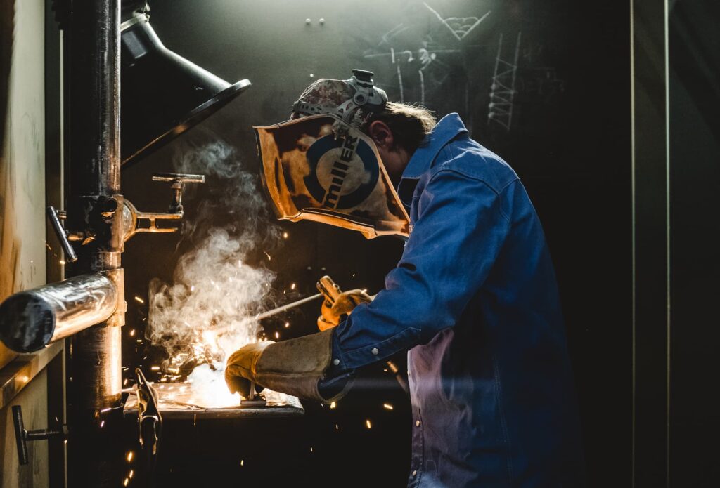 Student welding with sparks flying off